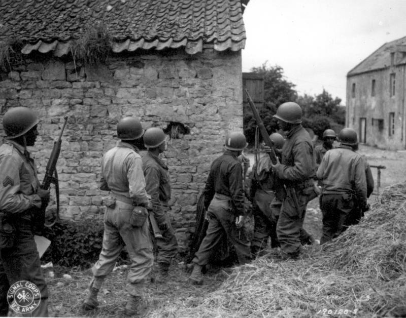 A platoon of Negro troops surrounds a farm house