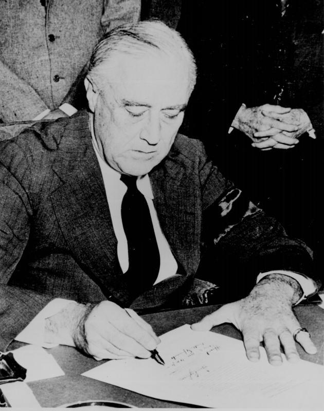 President Franklin D. Roosevelt signing the Declaration of War against Japan