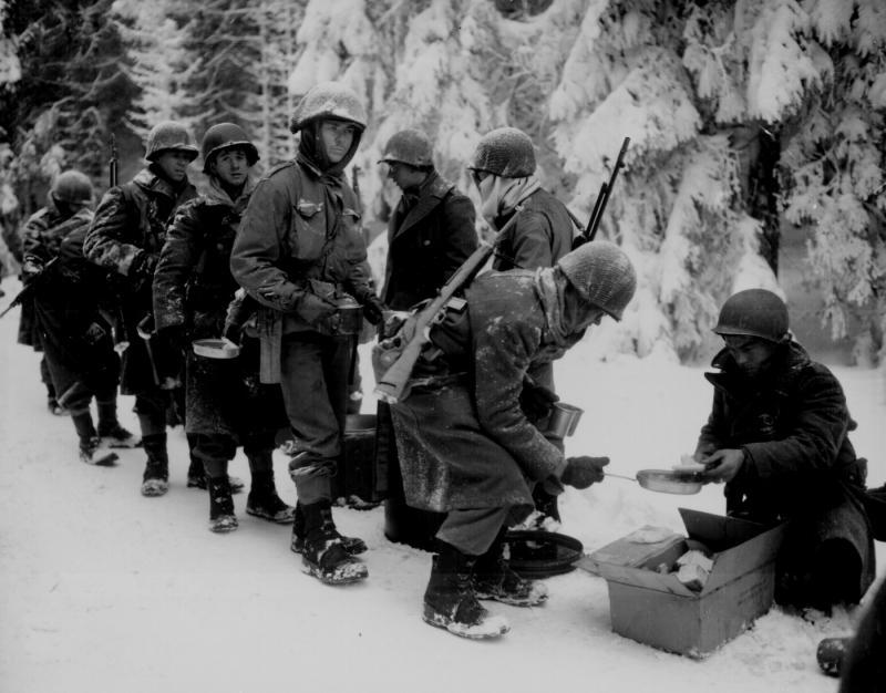 Chow is served to American Infantrymen on their way to La Roche, Belgium