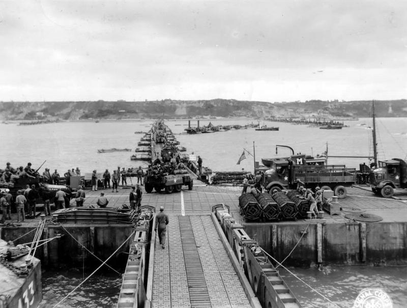 Military vehicles move ashore from Mulberry Artificial Harbor