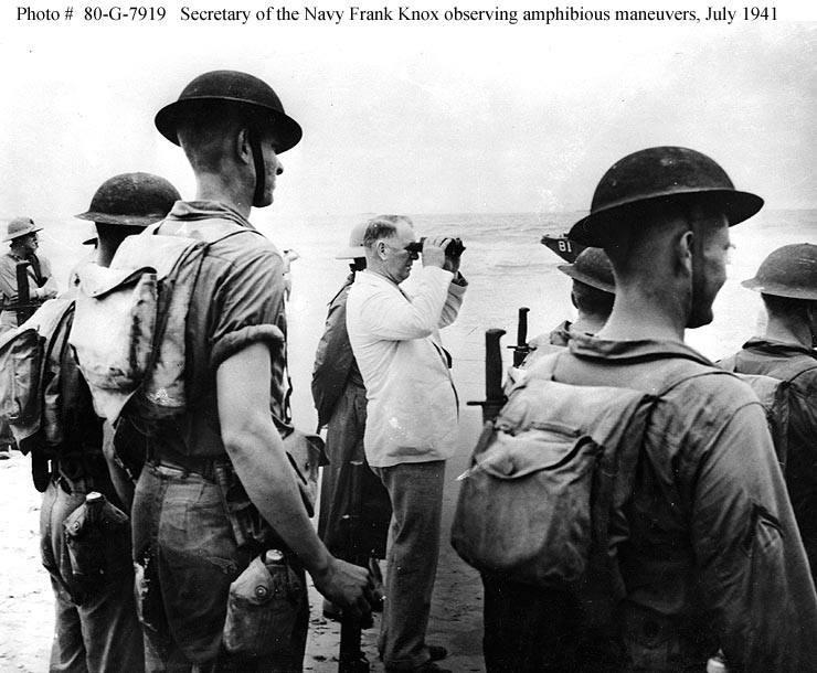 Frankas Knoxas stovi su JAV jūrų pėstininkais, stebėdamas bendrus manevrus ties New River Inlet