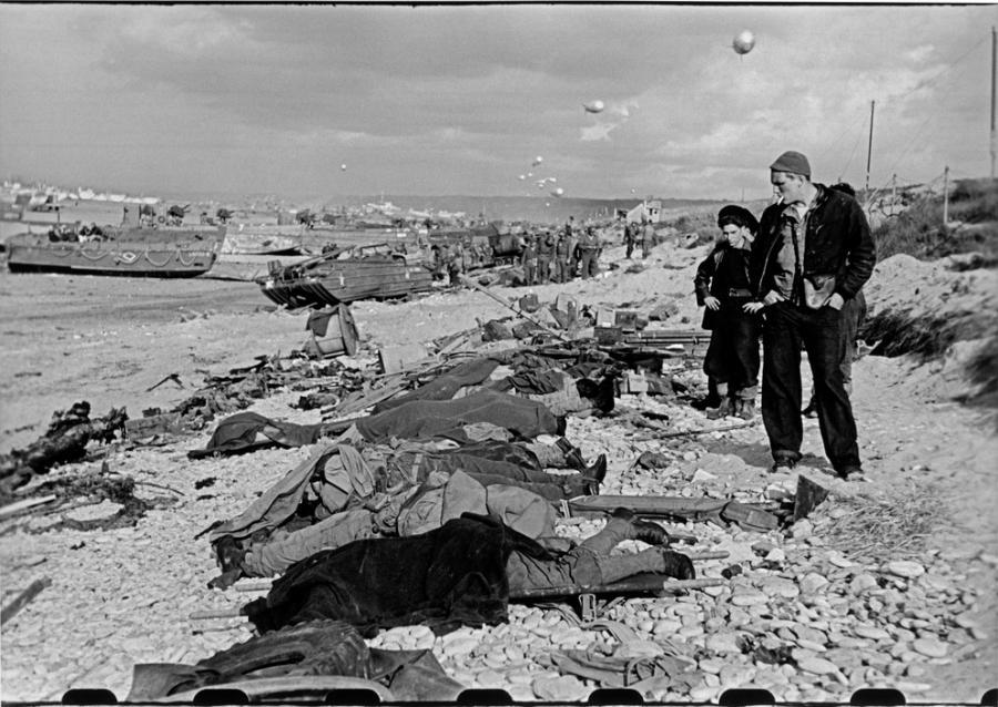 Photo by Robert Capa, French fishermen looking at the corpses Omaha Beach